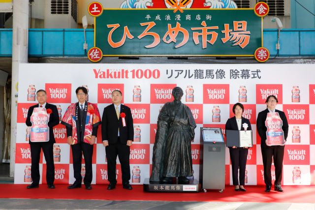 像の完成を記念して、高知県の「ひろめ市場」で開催された「『Yakult（ヤクルト）1000』リアル龍馬像　除幕式」の様子。