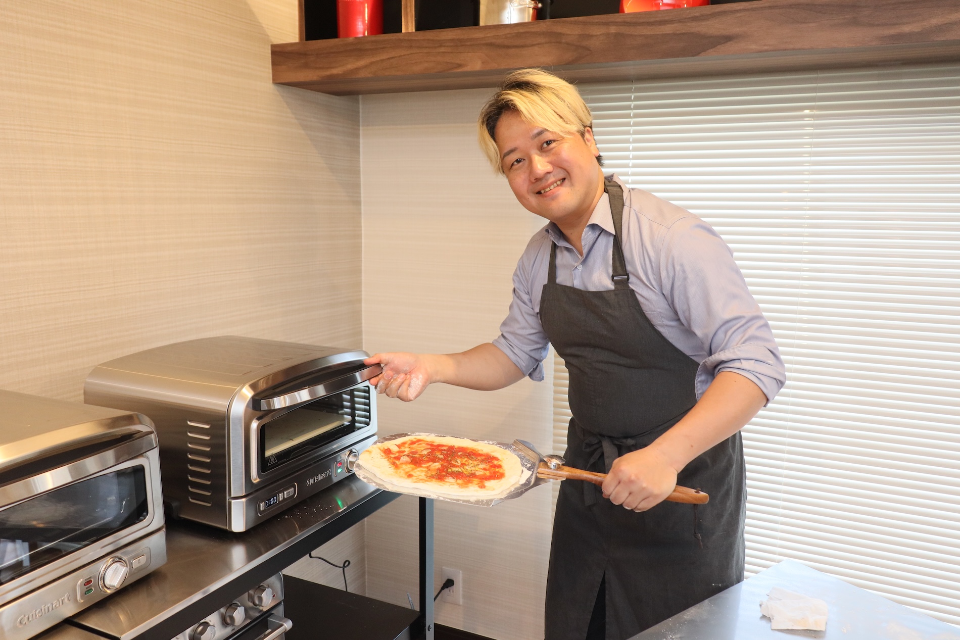 ピザオーブンにピザを入れる大西哲也