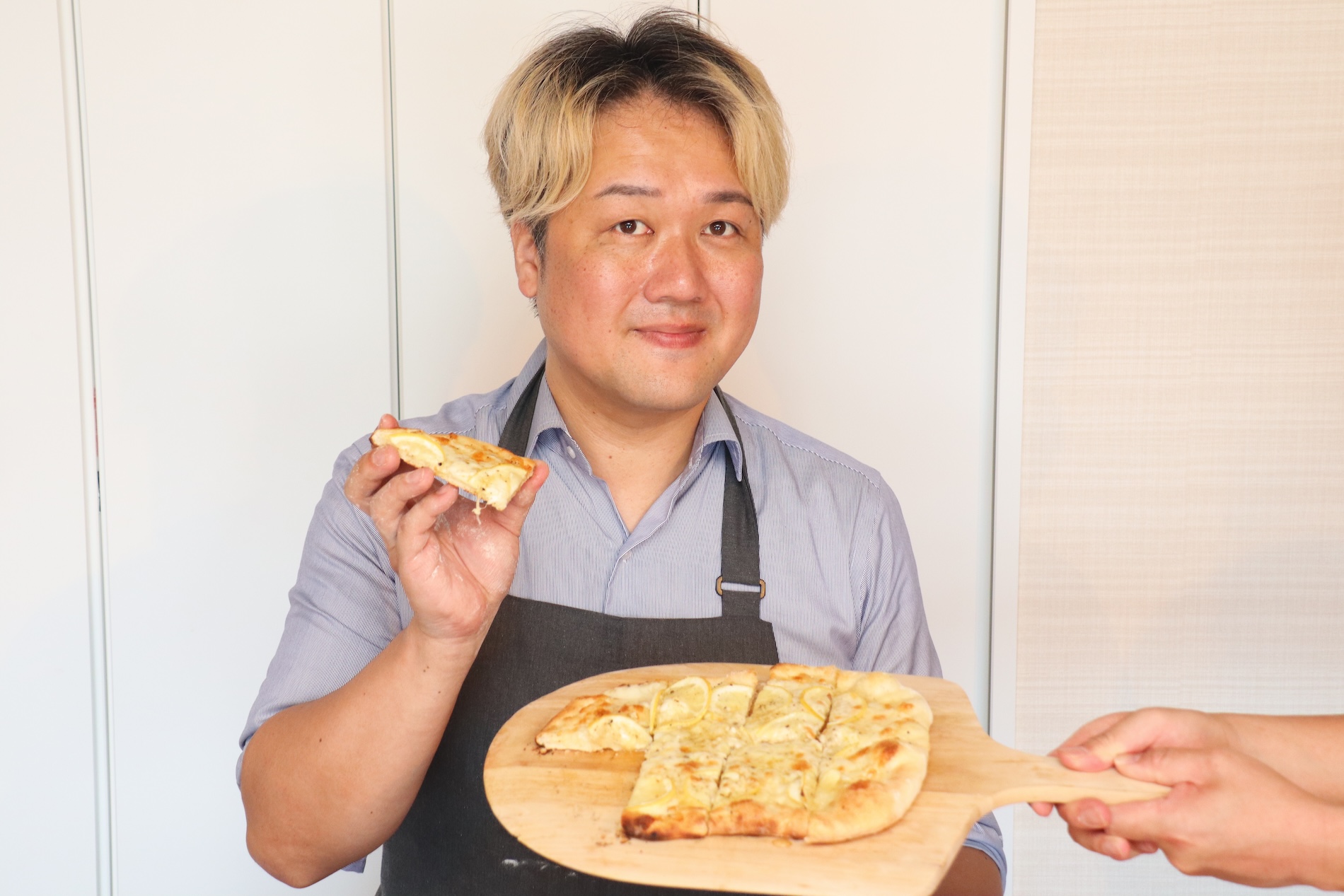 焼いたピザを持つ大西哲也