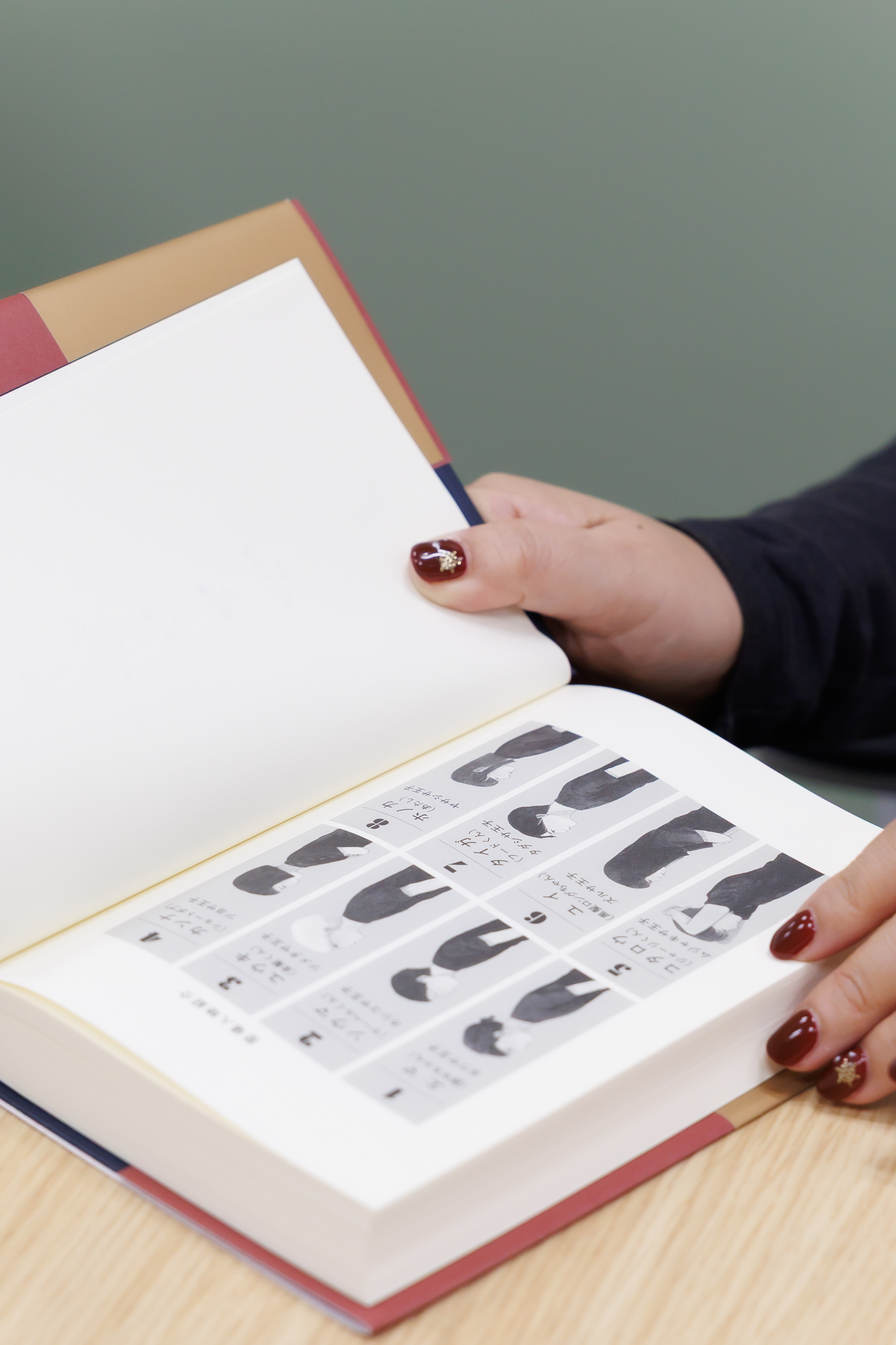 『いちばんうつくしい王冠』の紙面をめくる辻村氏。