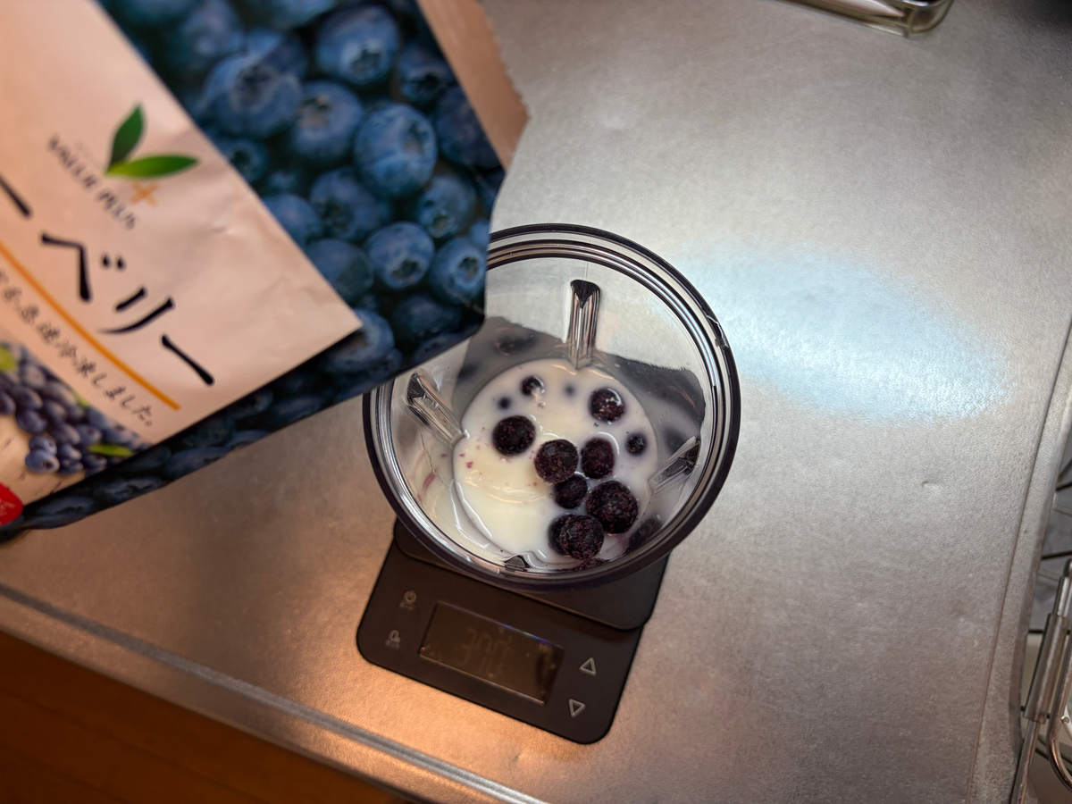 ブレンダーカップに豆乳、ヨーグルト、ブルーベリーを入れる様子