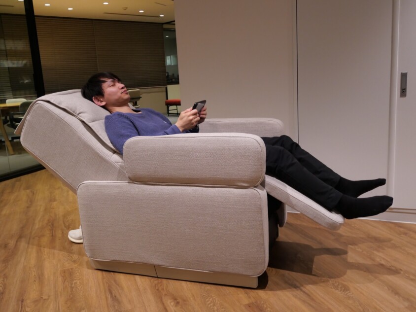 背もたれを倒れてマッサージを受けている様子