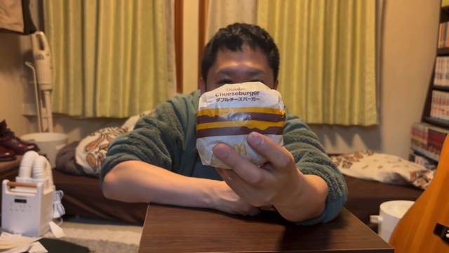 ダブルチーズバーガーを食べるドンデコルテ・渡辺