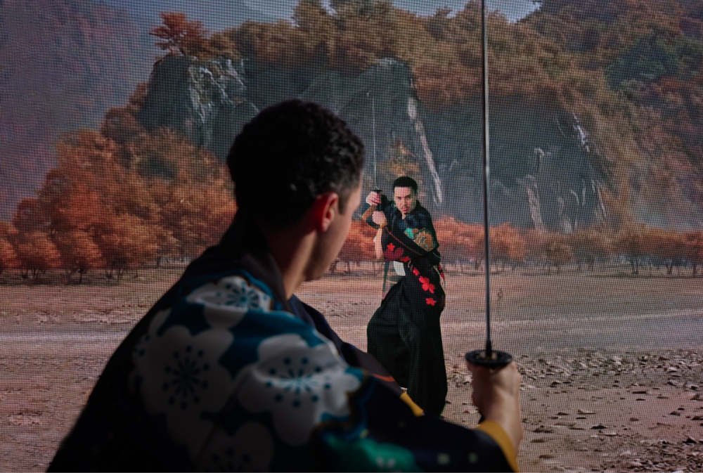 超大型ビジョンに映る師範に合わせて刀を振る