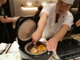 炊き上げ米をすくい上げる