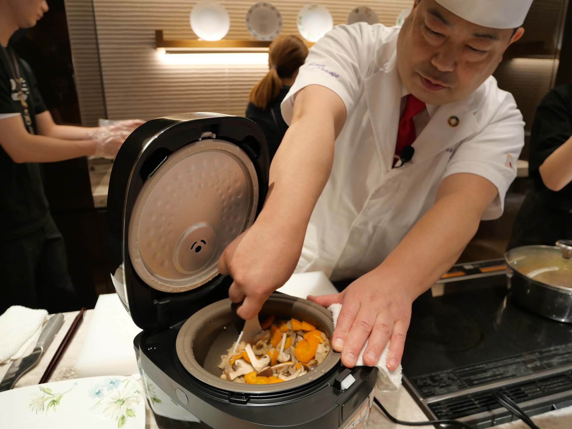 炊き上げ米をすくい上げる