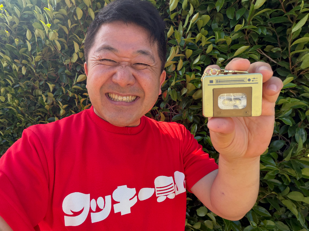 『ミニチュアカラフルテープレコーダー』を手にするワッキー貝山