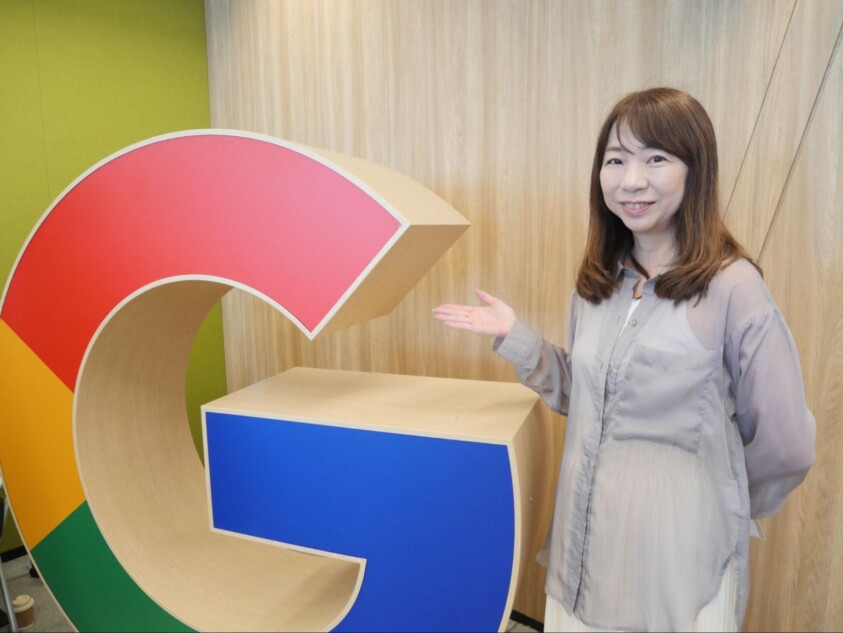 Googleのロゴの前に立つ担当者