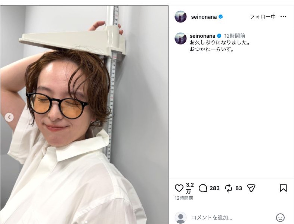 眼鏡をかけた清野菜名が身長計のバーに手を添え、目を閉じてほほ笑む
