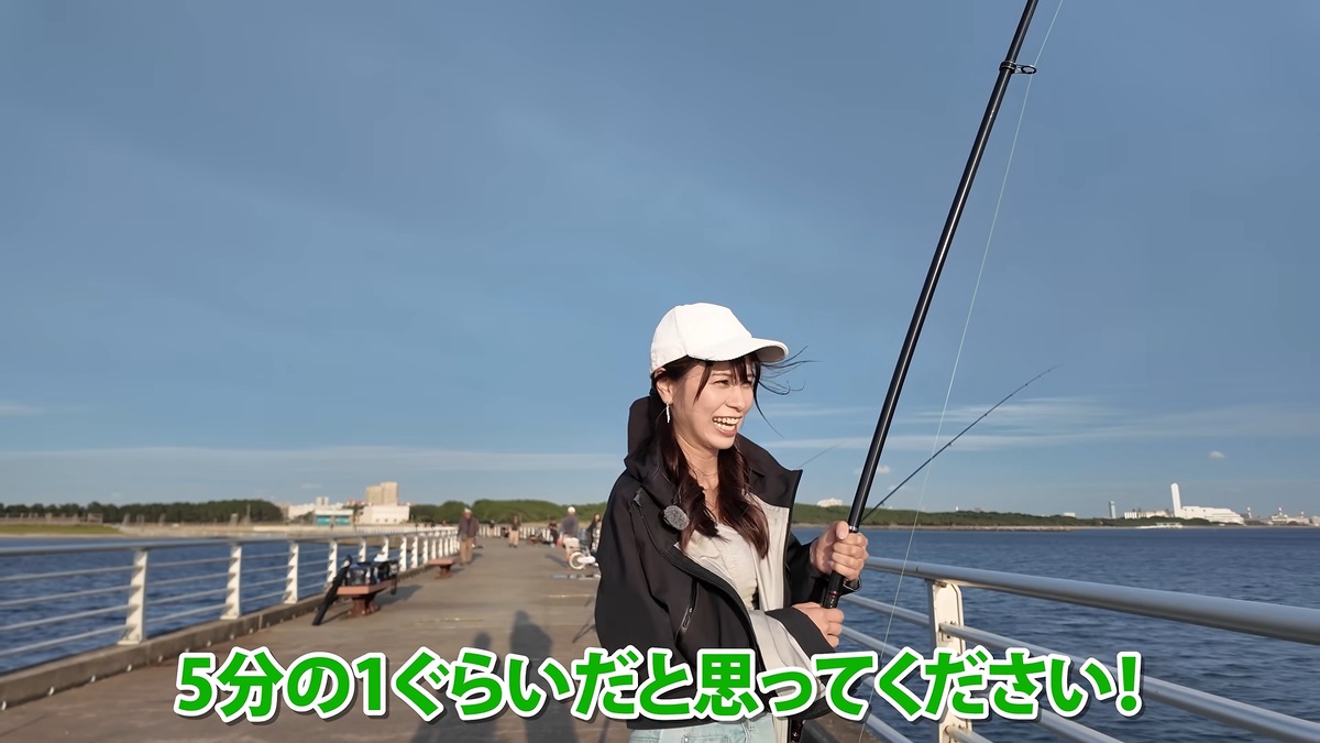 泳がせ釣りで竿を持ち、リールを巻くあま猫
